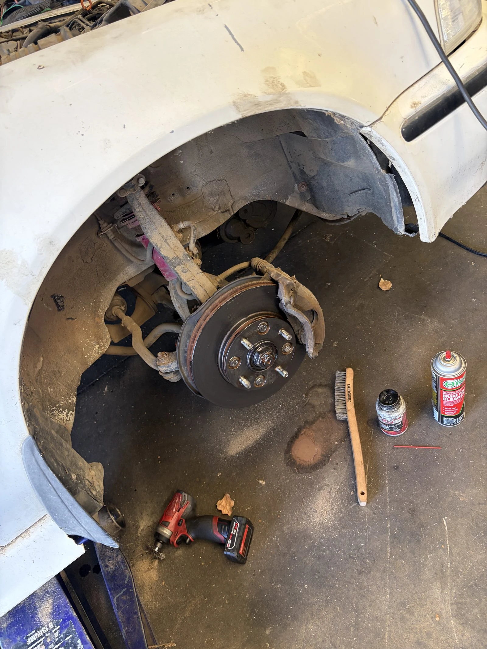A front brake job in progress in the Supercanic shop, wheel off and caliper exposed