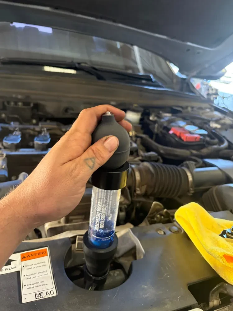 A Supercanic mechanic running a block test on a coolant reservoir