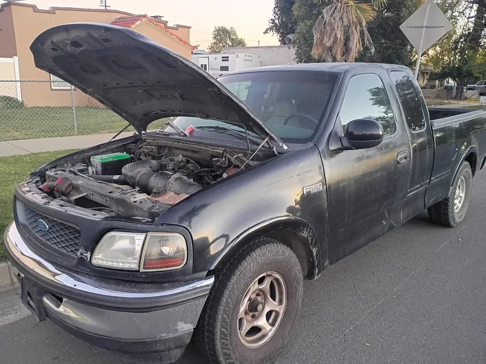A Ford F-150 with the hood up at the curb in Beaumont, fixed where it sat