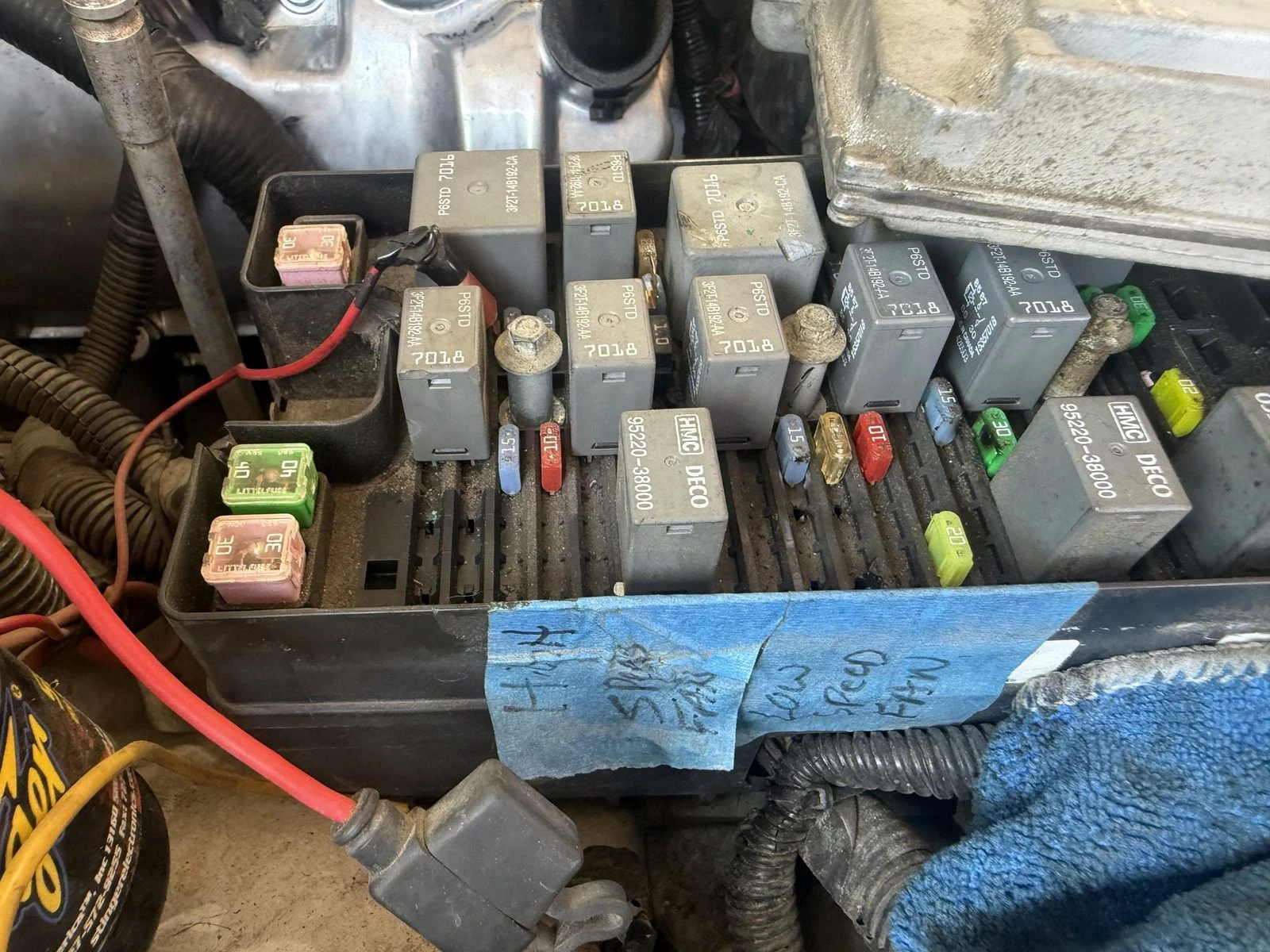 Relay and fuse box on a Hemet repair job with blue tape notes marking the high speed and low speed fan relays