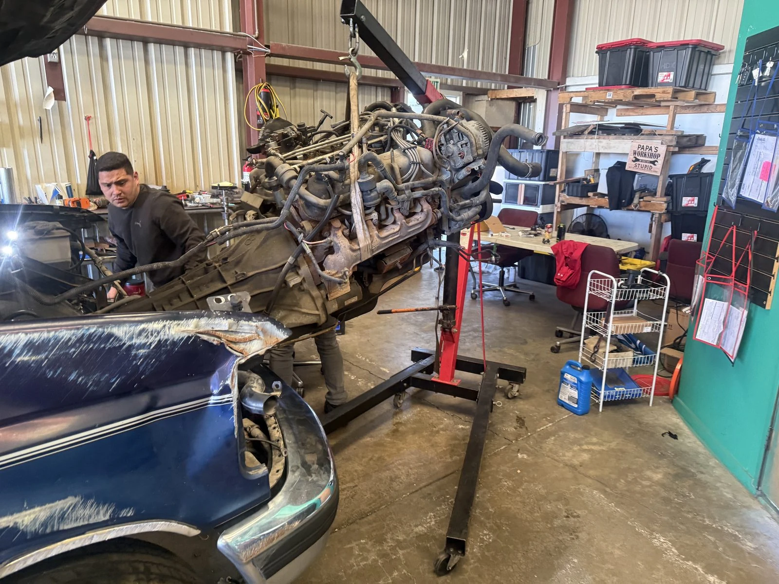 An engine coming out of a Ford F-250 in the Supercanic shop