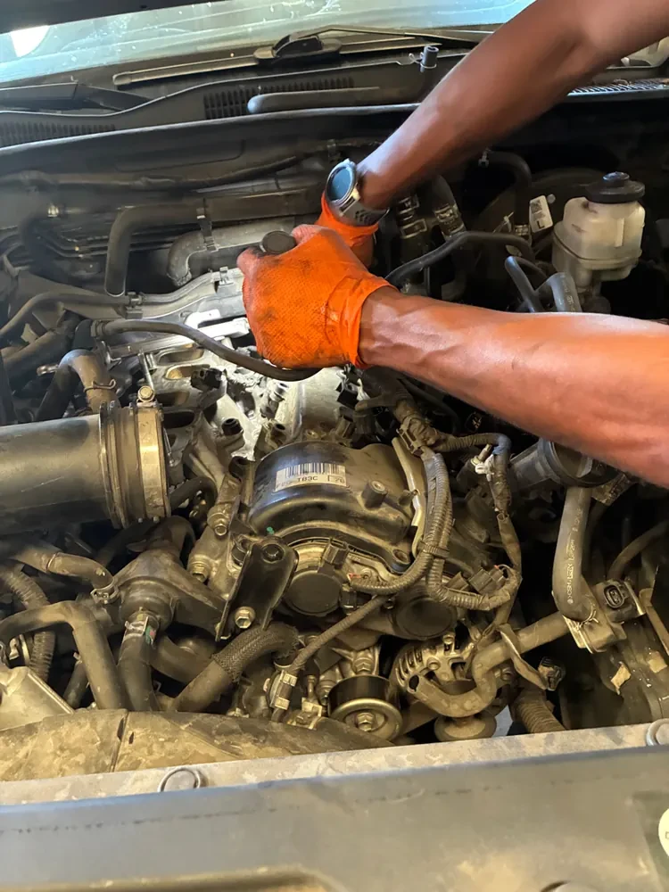 A Supercanic mechanic's gloved hands working in an engine bay